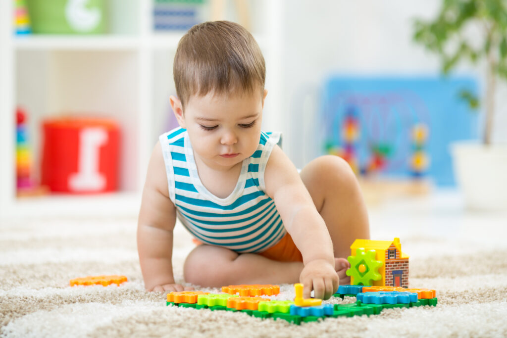 A male baby plays with toys at daycare.