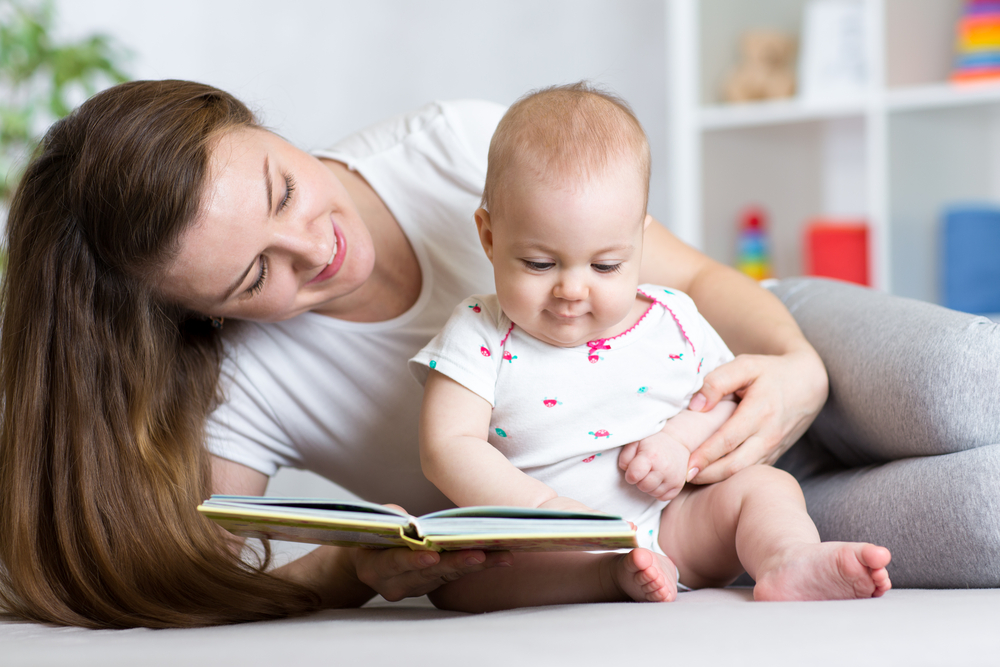 Parent reading to her infant.